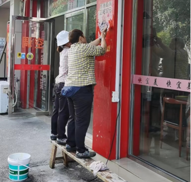 员工正在铲除小广告 员工正在铲除小广告